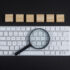 Vergrootglas op toetsenbord als symbool voor SEO content analyse en Google beoordeling.