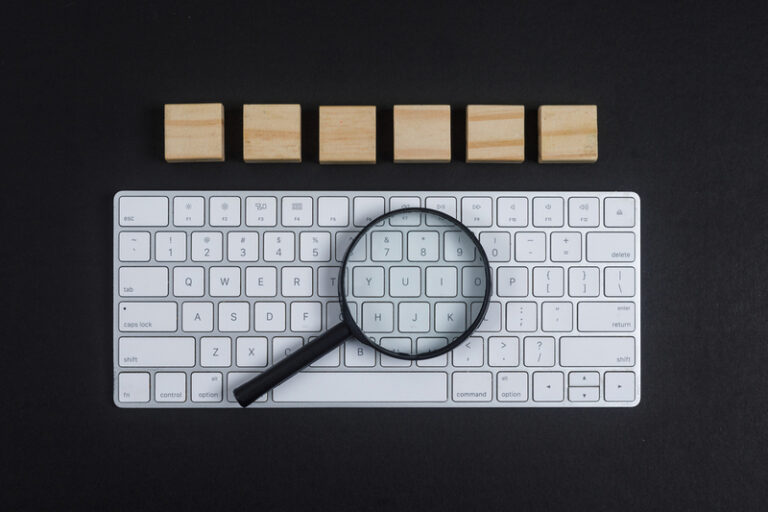 Vergrootglas op toetsenbord als symbool voor SEO content analyse en Google beoordeling.